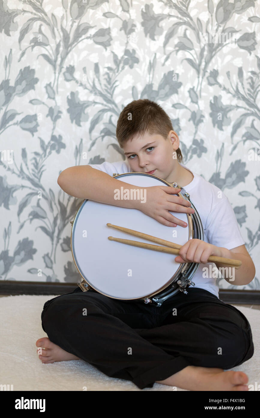 Teenager boy with a drum in  room Stock Photo