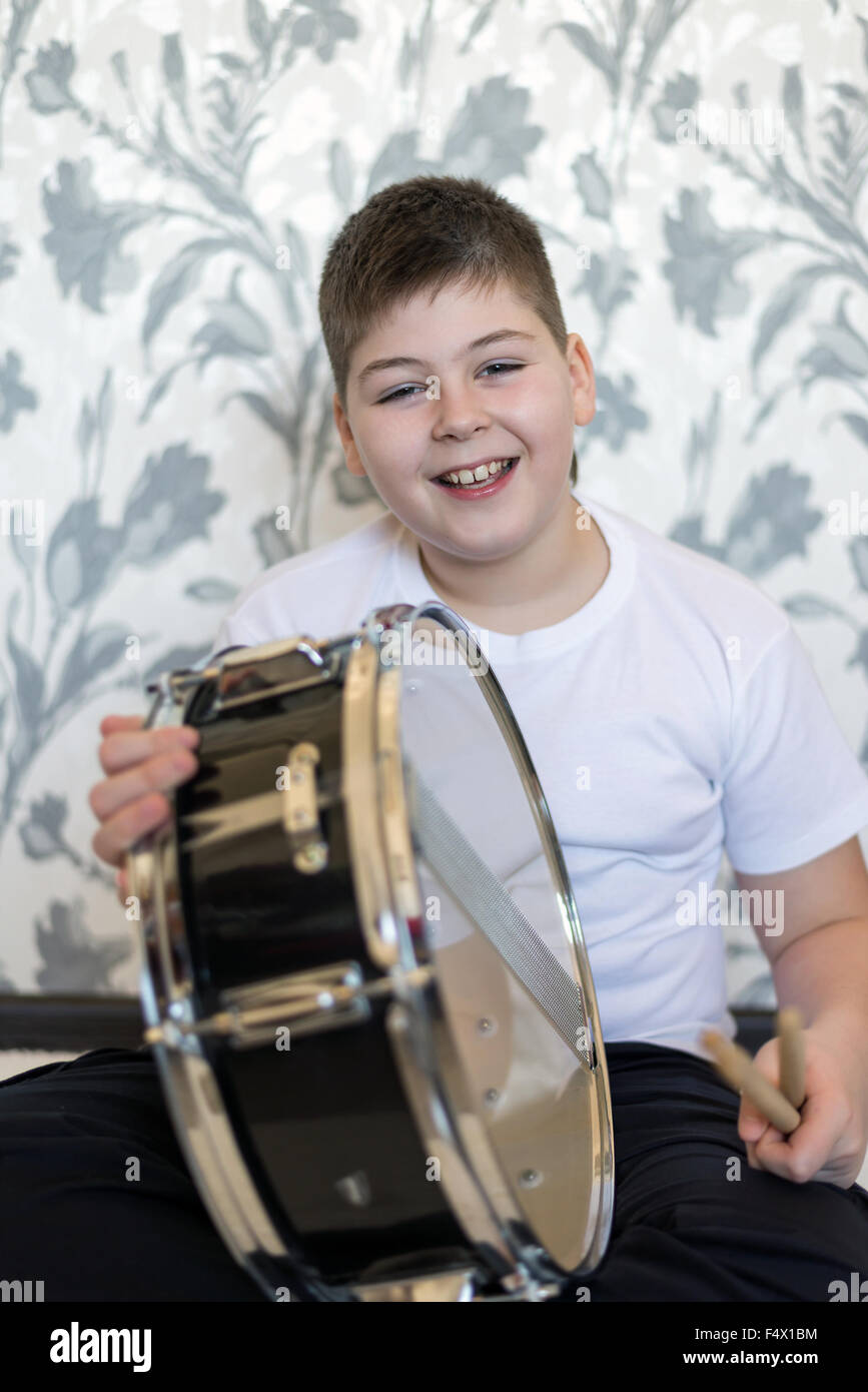 Teenager boy with a drum in  room Stock Photo