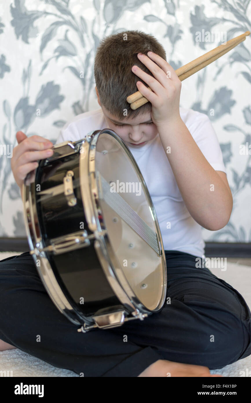 Teenager boy with  drum holding his head Stock Photo
