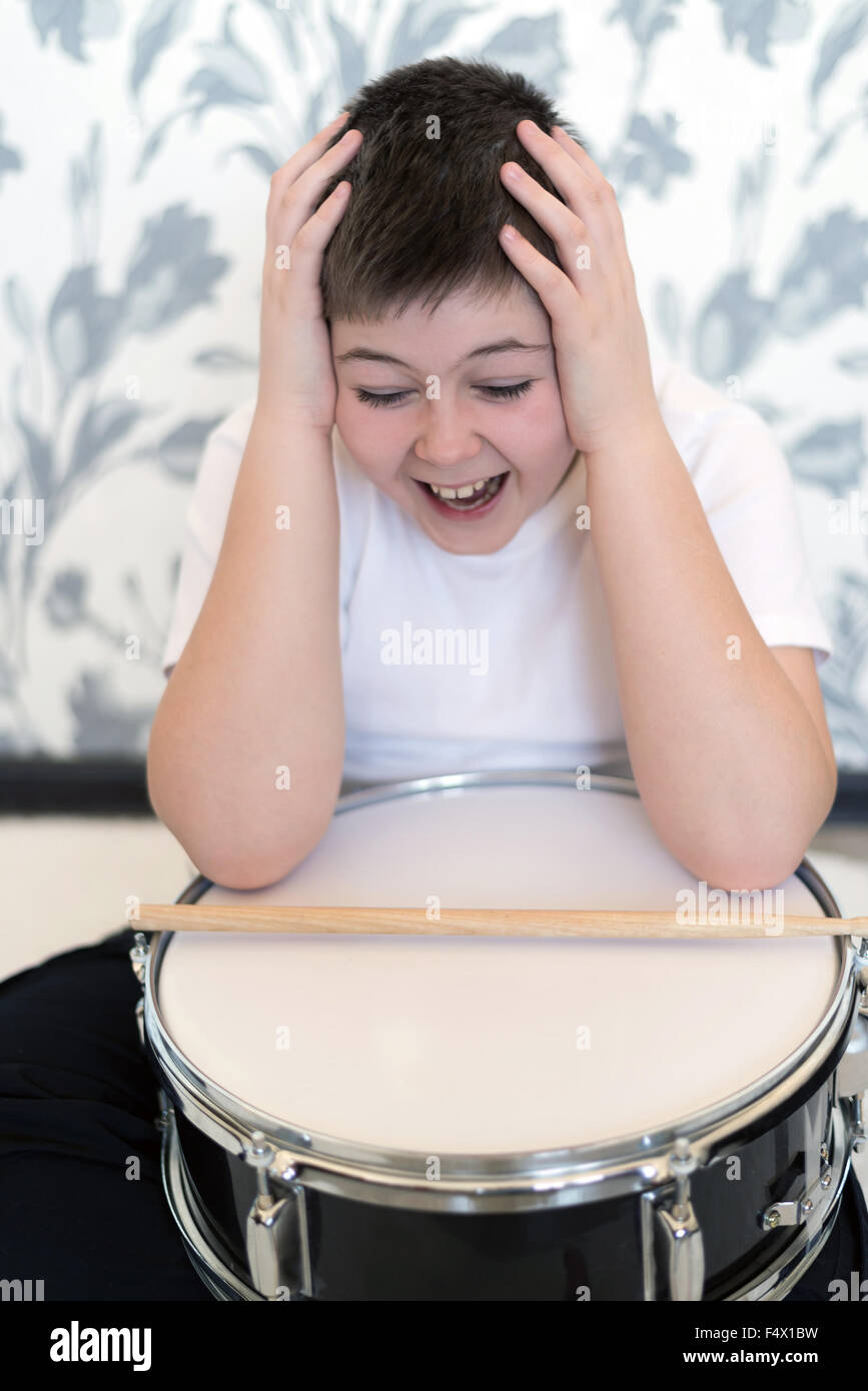 Teenager boy with  drum holding his head Stock Photo