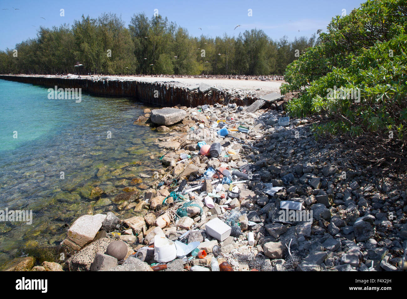 Plastic and glass marine debris washed ashore in the harbor of a North Pacific island Stock Photo