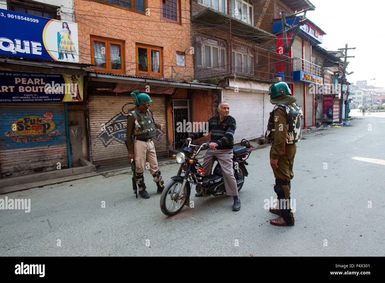 Srinagar, Indian-controlled Kashmir. 23rd Oct, 2015. Indian paramilitary soldiers stop a Kashmiri man on motorcycle during restrictions in old city of Srinagar, summer capital of Indian-controlled Kashmir, Oct. 23, 2015. The authorities on Friday imposed strict restrictions in several areas of restive Indian controlled Kashmir to disallow protest programme of separatist leaders and prevent clashes over killing of a trucker. Credit:  Javed Dar/Xinhua/Alamy Live News Stock Photo