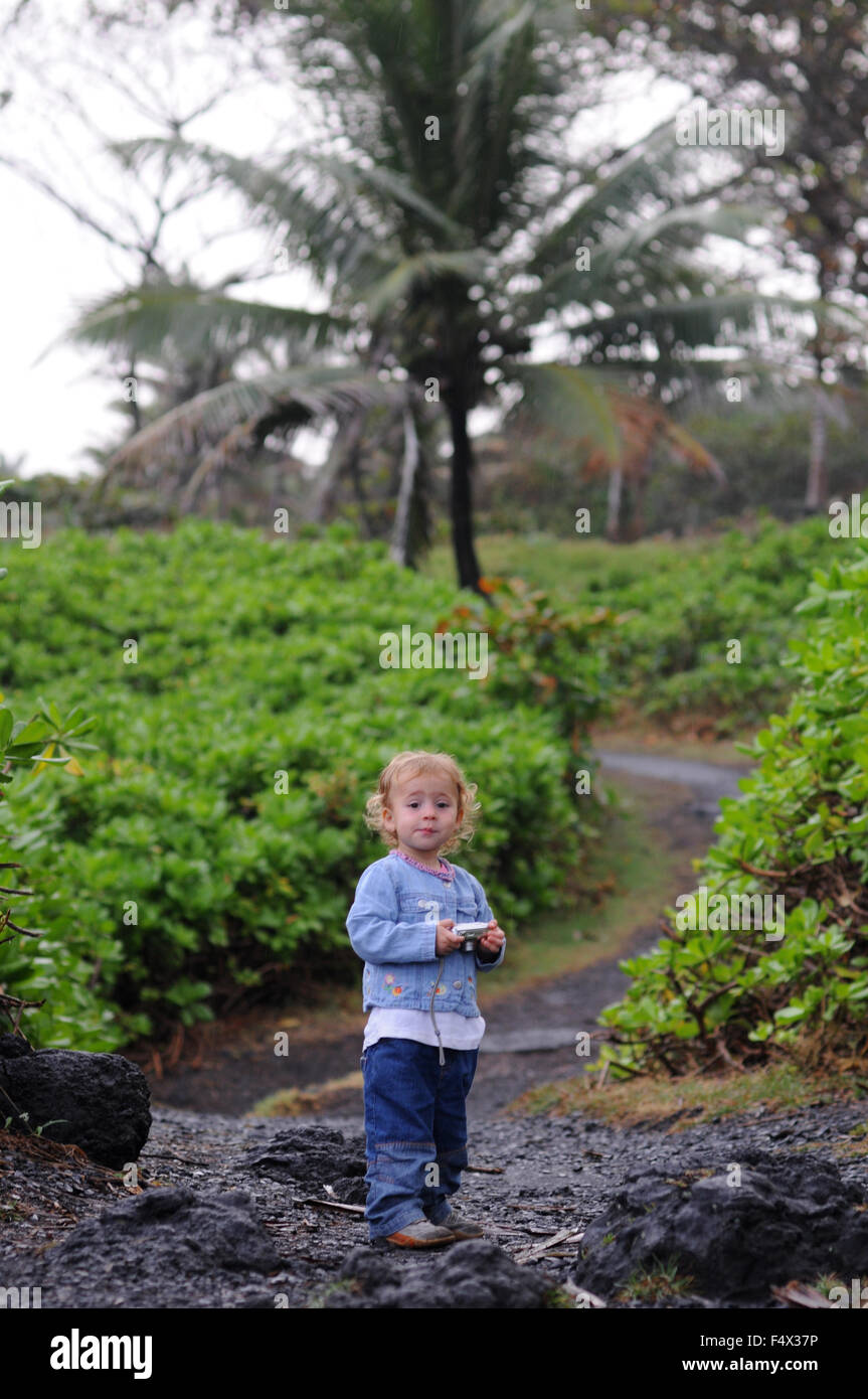 Child in Wai'anapanapa State Park. A leafy location with sea caves and volcanic cliffs. Hana Highway. Maui. Hawaii. This is a gr Stock Photo