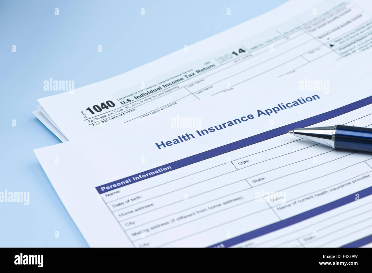 Health insurance application with United States 1040 tax form and pen. Stock Photo