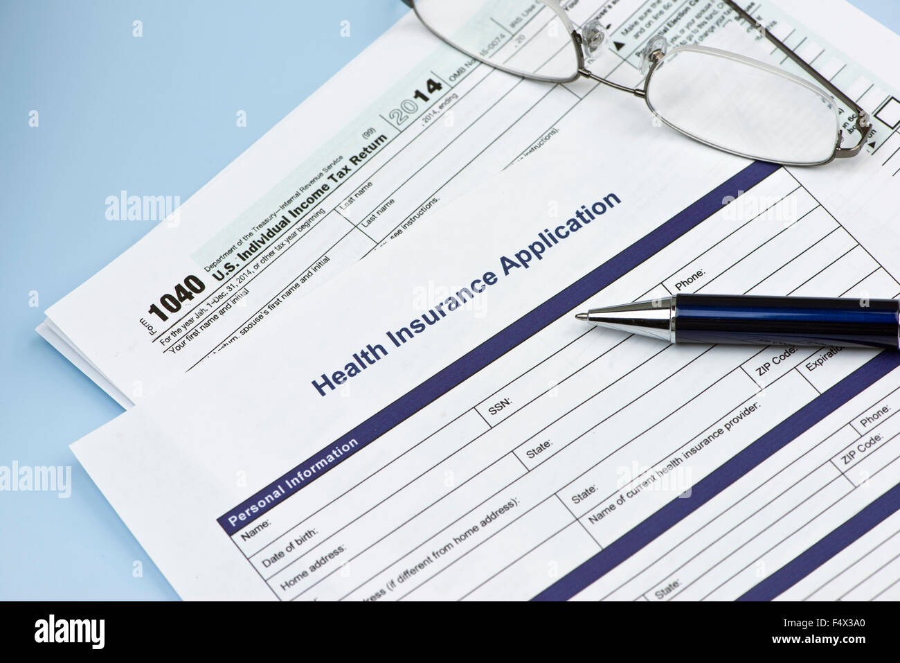 Health insurance application with United States 1040 tax form with glasses and pen. Stock Photo