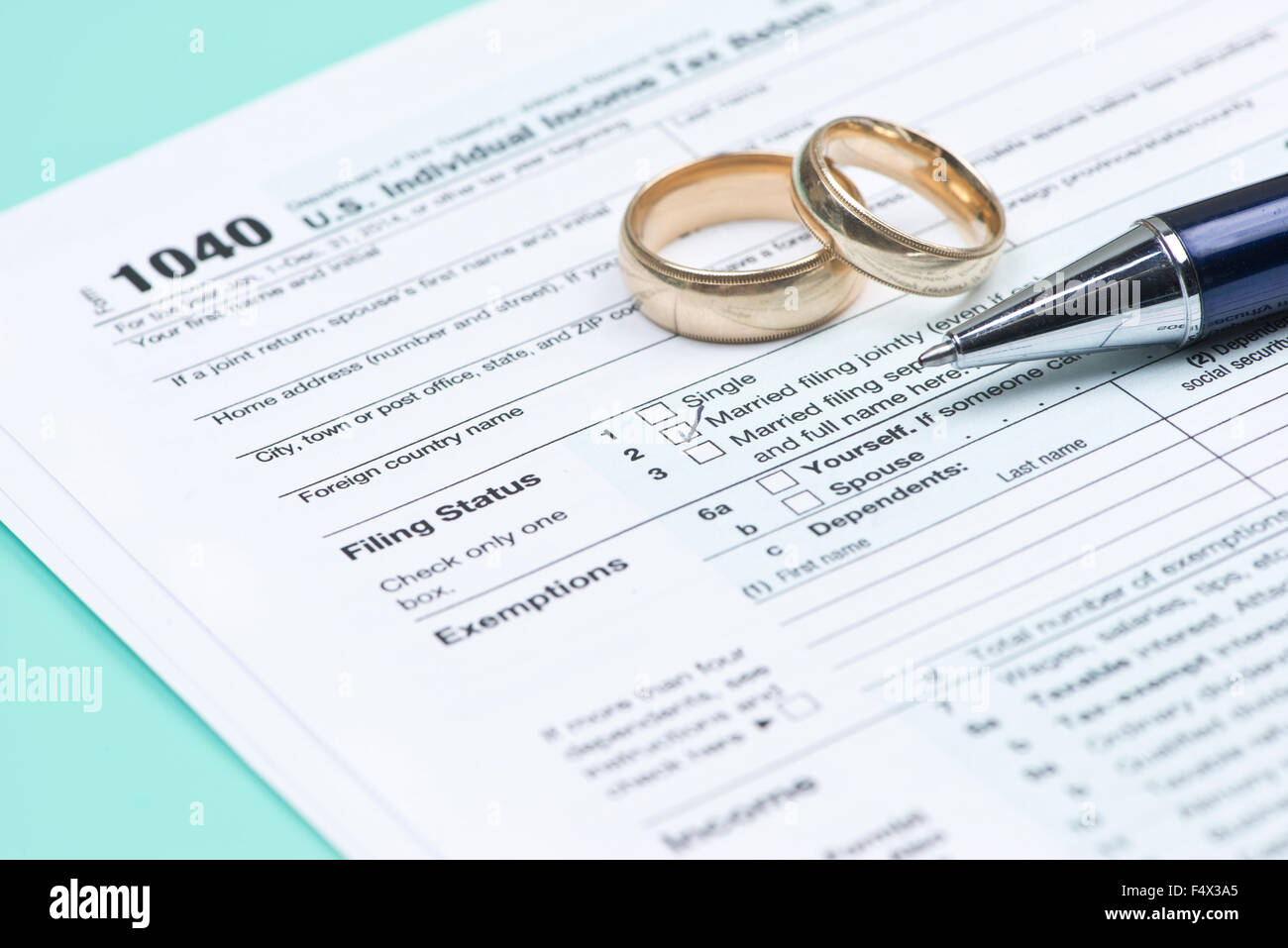 Wedding rings with United States tax form 1040 and pen. Stock Photo