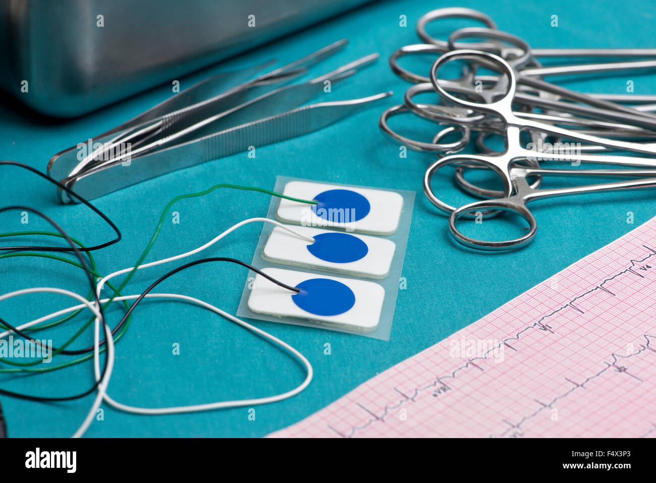 Electrocardiogram leads and electrocardiograph on surgical table. Stock Photo