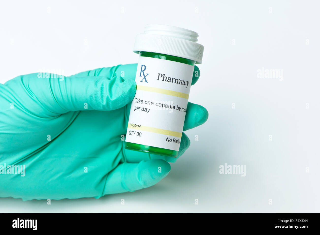 Nurse with gloved hand holds green prescription bottle Stock Photo Alamy