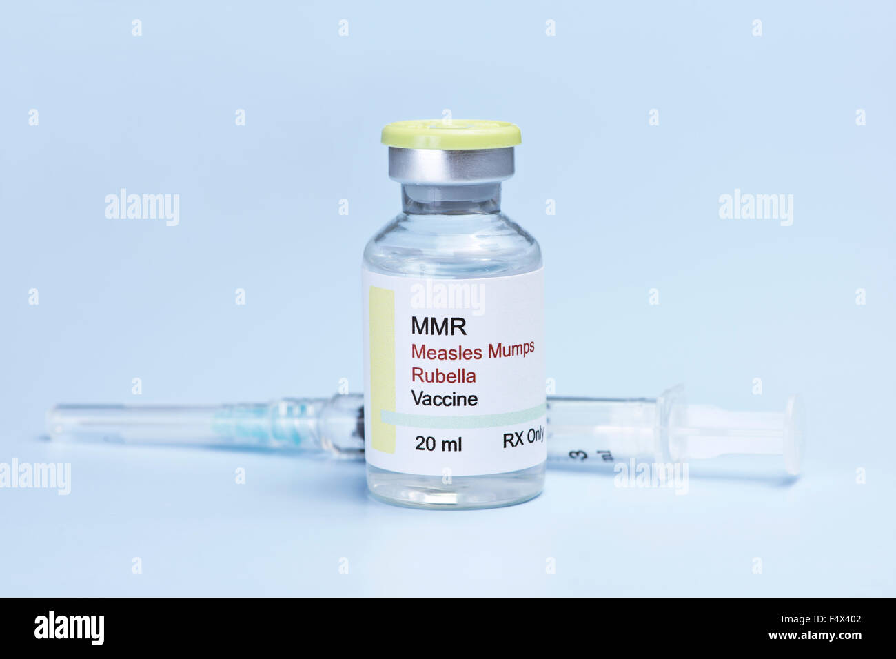 Measles, mumps, rubella, virus vaccine and syringe on blue background. Stock Photo