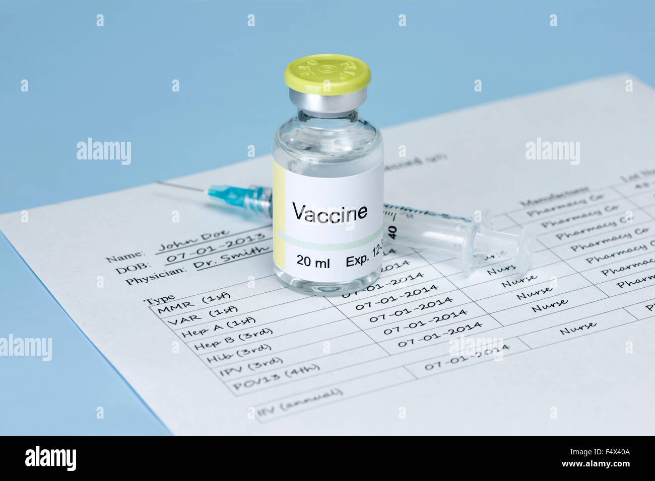 Vaccine vial with immunization record and syringe on white background. Label and record are fictitious. Stock Photo