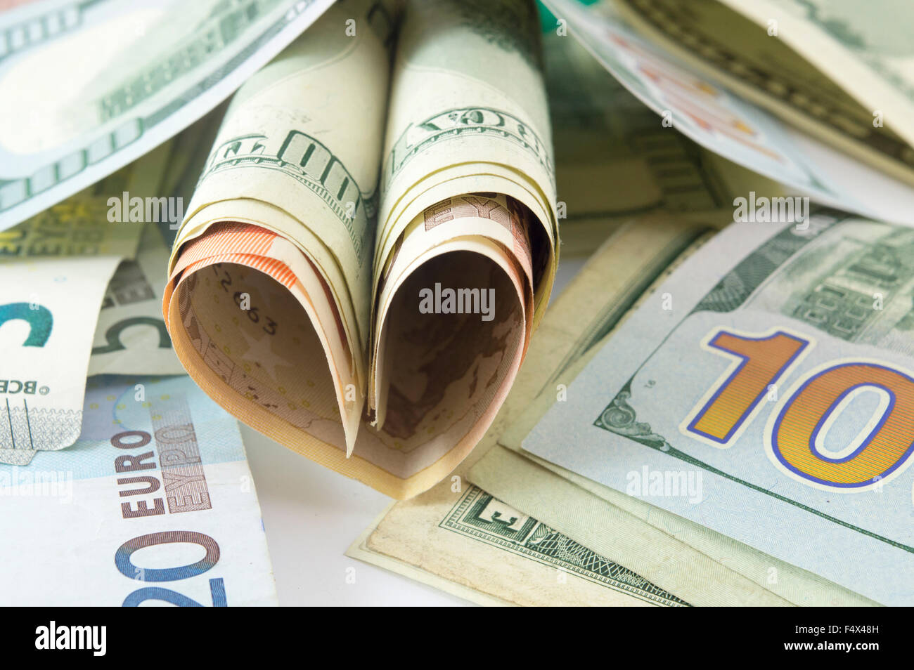 Bunch of dollar bills on the table forming a heart shape Stock Photo