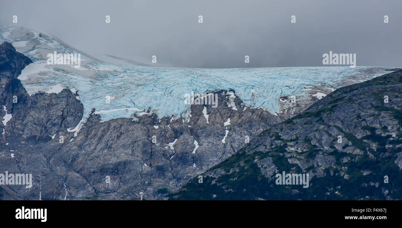 Hanging glaciers and clouds on the mountain tops near port of Skagway Alaska | Lynn Canal fjord cruise - inside passage Stock Photo