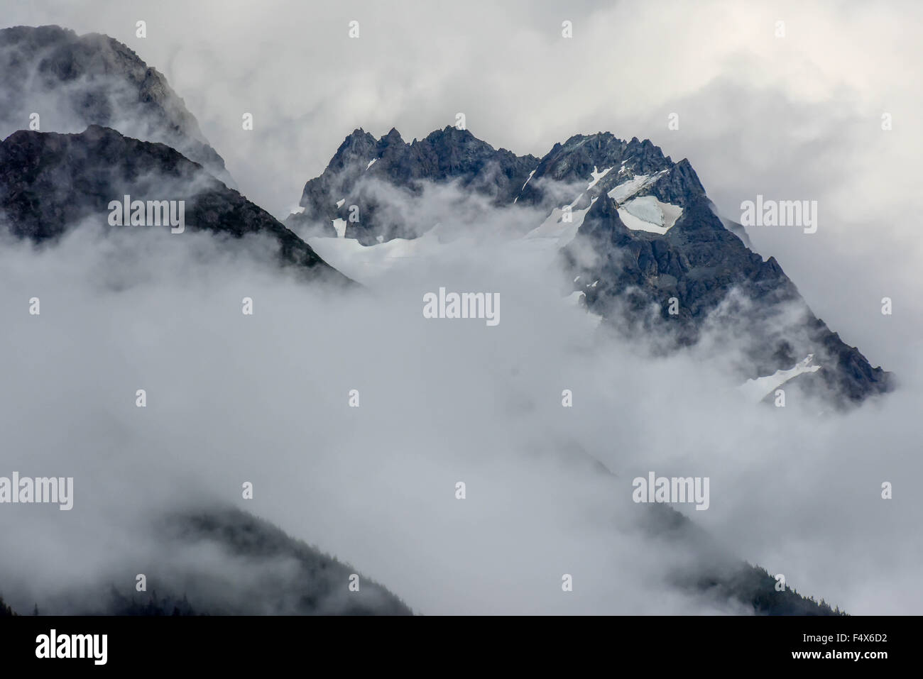 Hanging glaciers and clouds on the mountain tops near port of Skagway Alaska | Lynn Canal fjord cruise - inside passage Stock Photo
