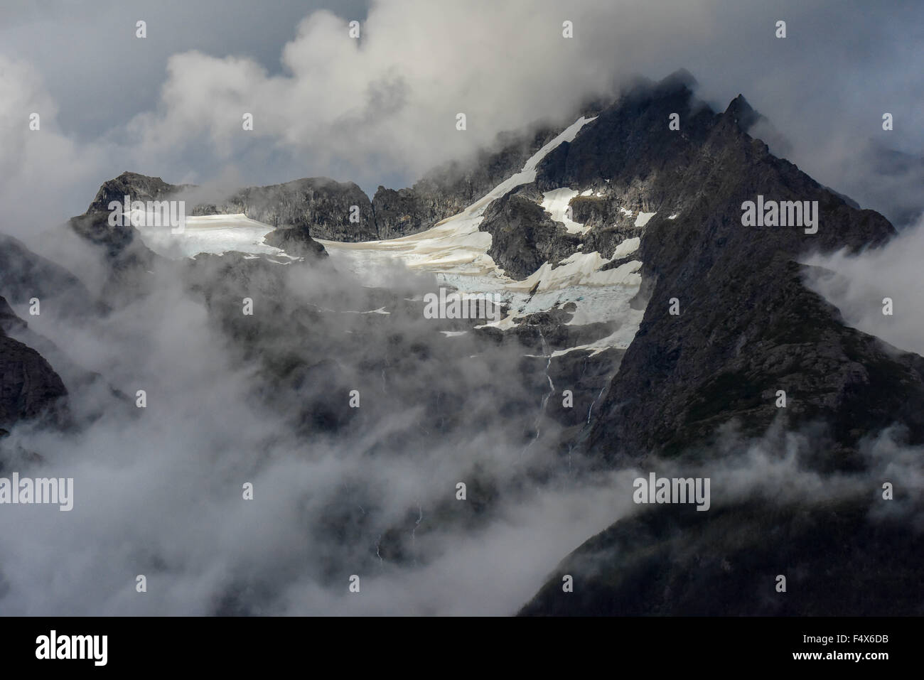 Hanging glaciers and clouds on the mountain tops near port of Skagway Alaska | Lynn Canal fjord cruise - inside passage Stock Photo