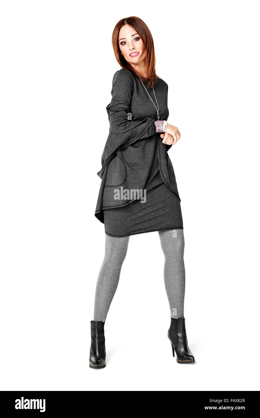 Studio portrait of a beautiful young woman posing in a gray dress. Look ...