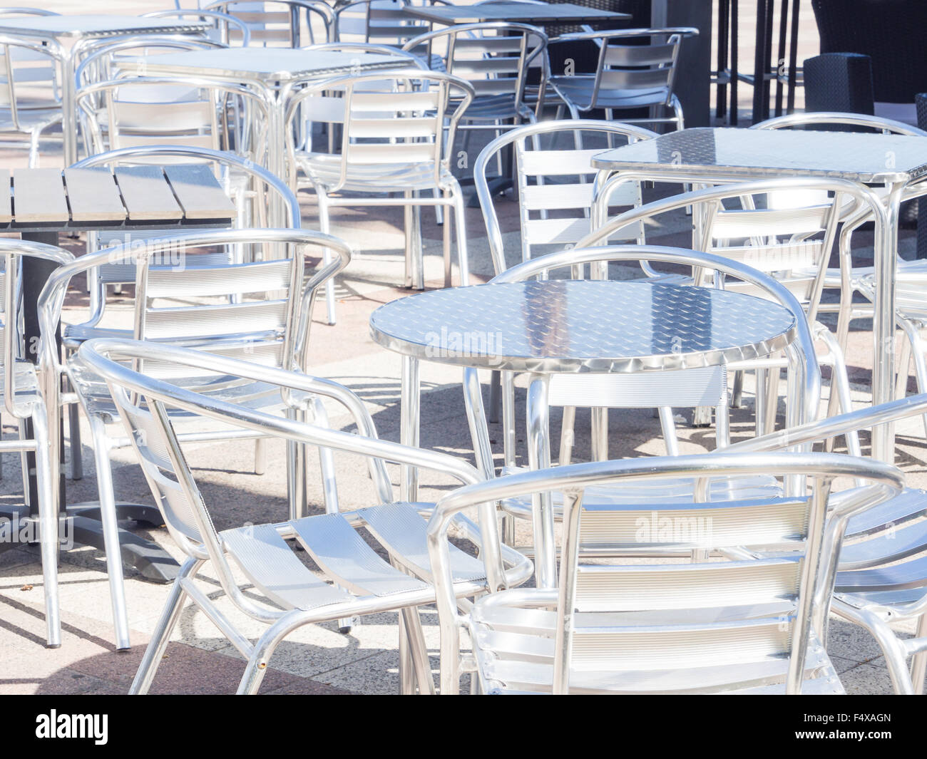 seats metallic reflection. several tables and metal chairs empty Stock Photo