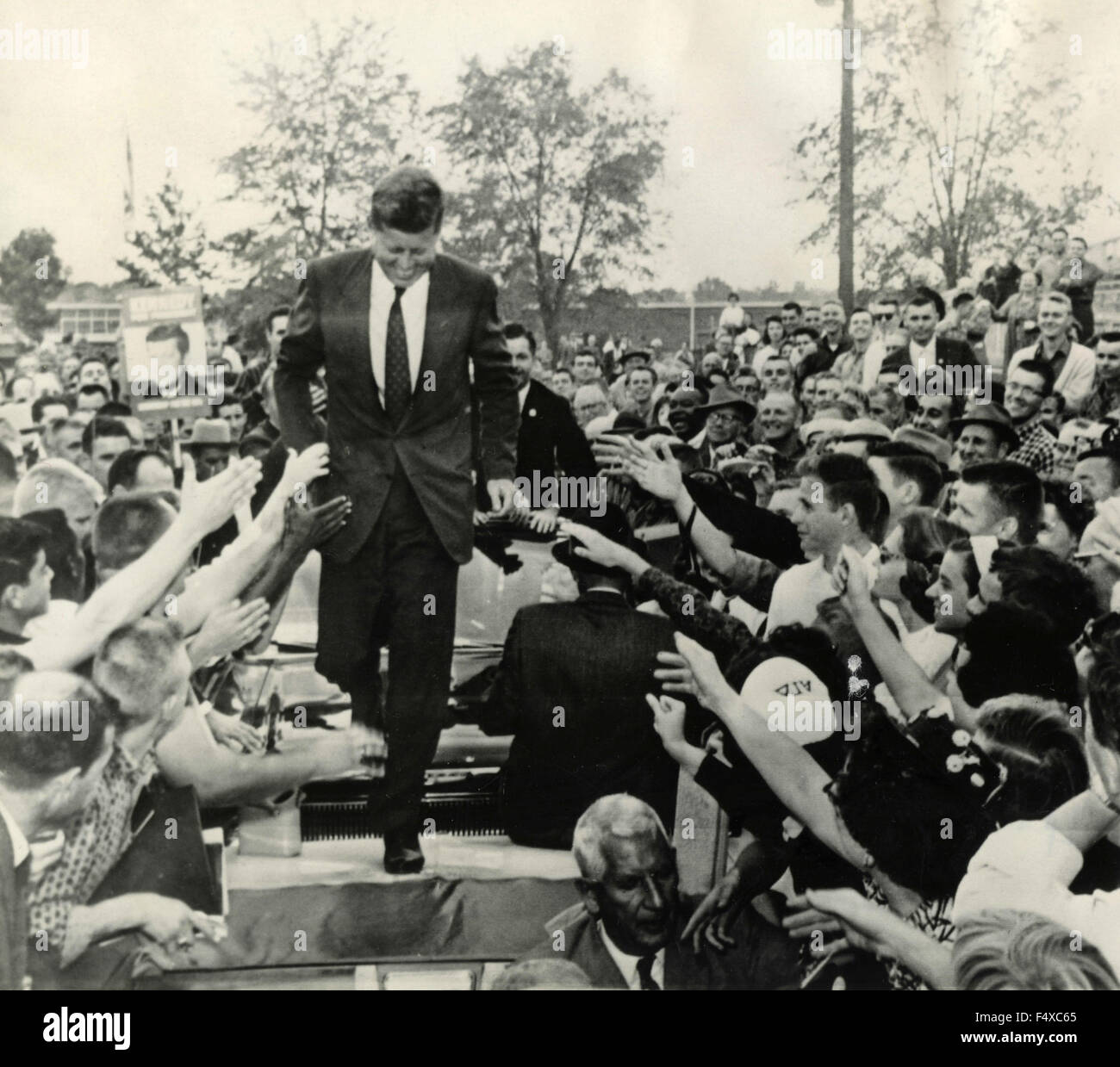 U.S. Senator John F. Kennedy, besieged by the crowd, walking on cars, Carbondale, Ill., USA Stock Photo