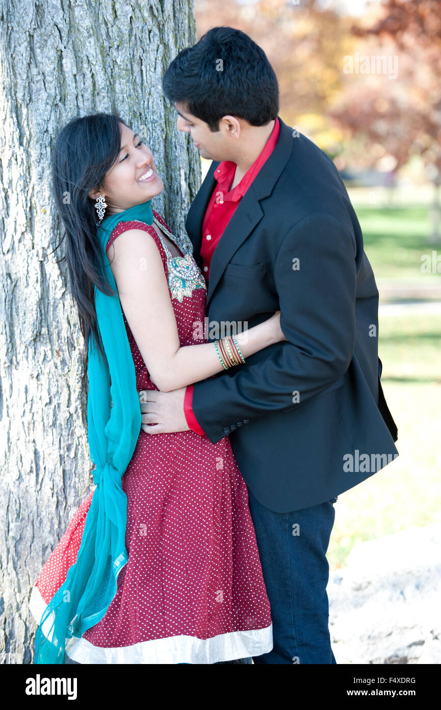 A young and happy Indian couple looking at each other in the fall near ...