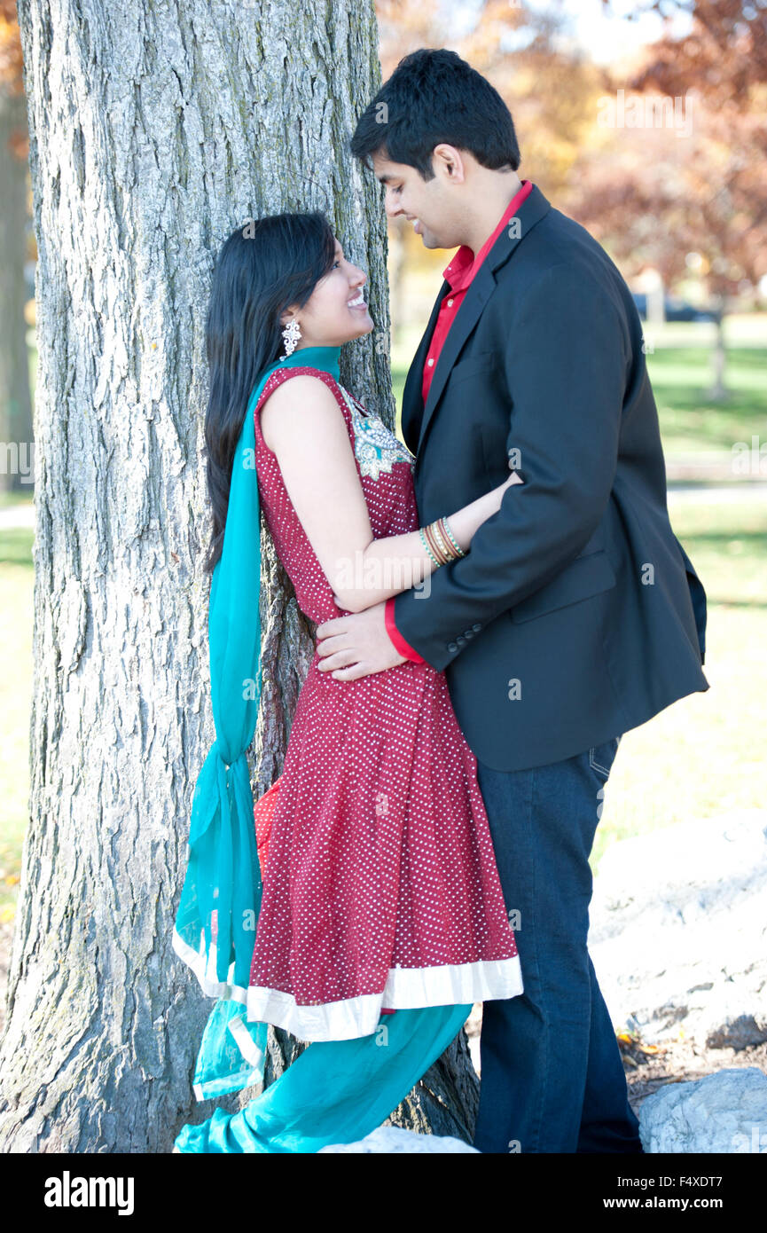 A young and happy Indian couple looking at each other in the fall near ...
