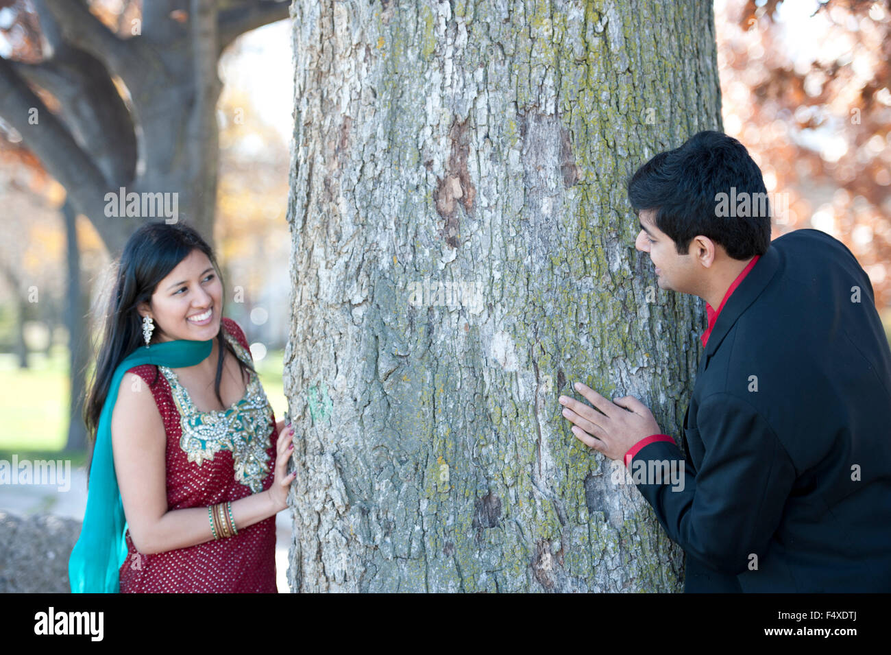 A young and happy Indian couple wearing traditional attire looking for ...