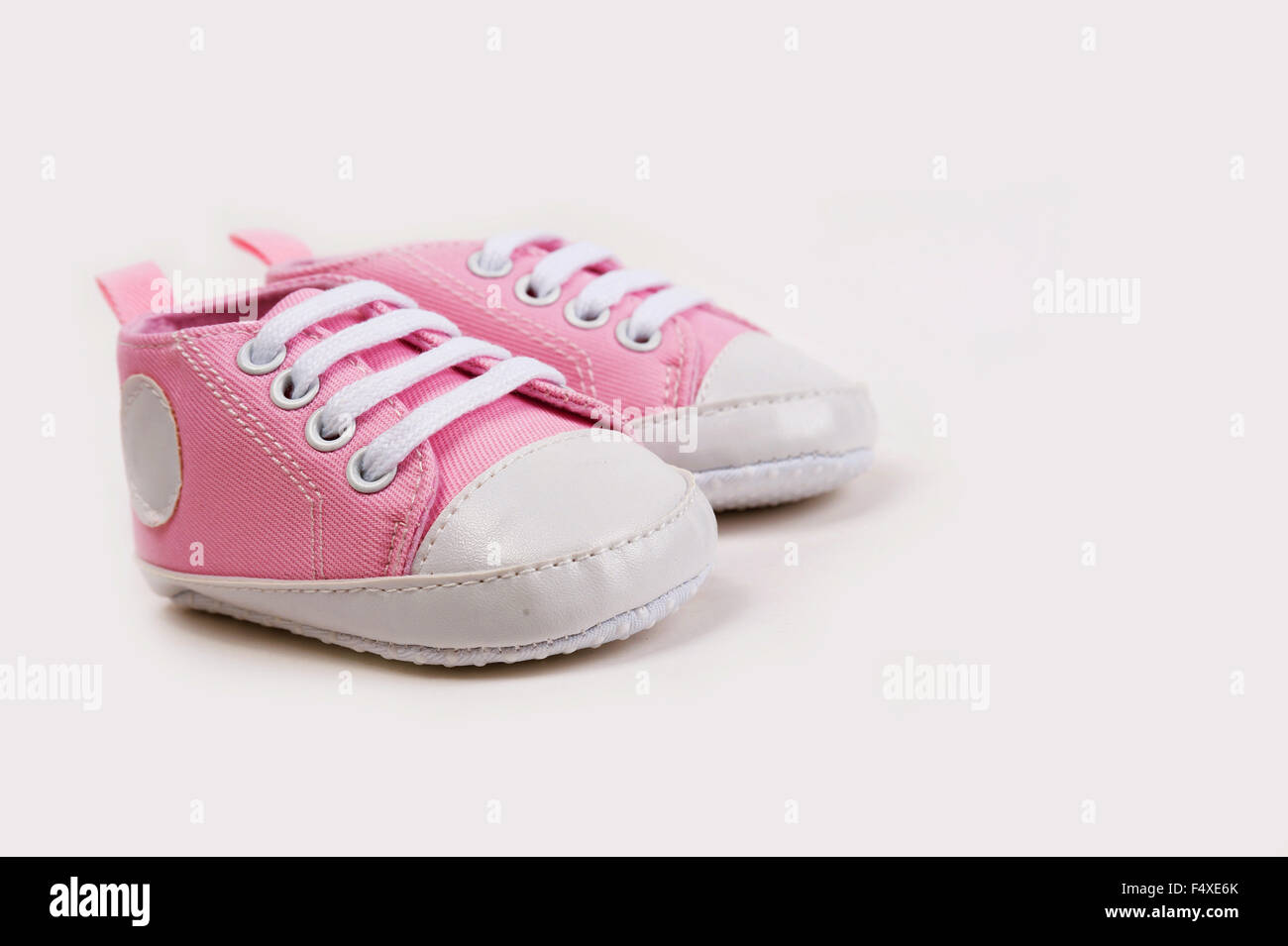 Cute pink baby girl shoes / sneakers on white background close up Stock Photo