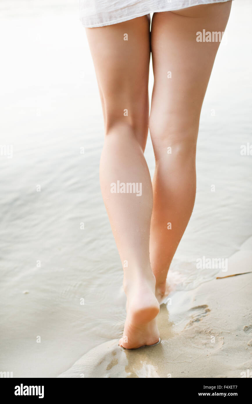 Woman walking on sand beach leaving footprints in the sand Stock Photo ...