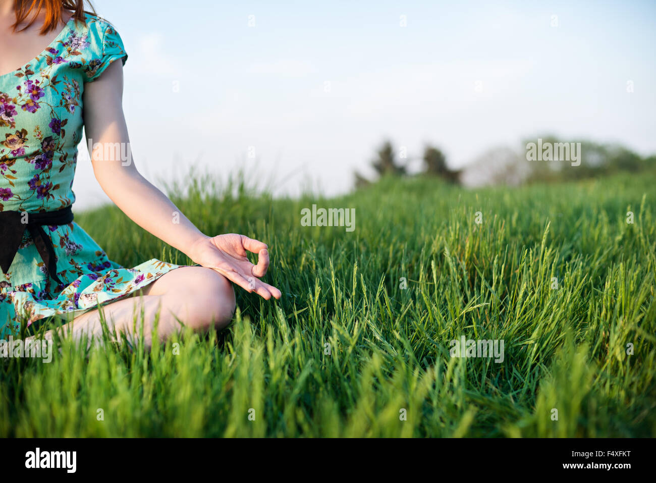 Pretty woman meditate sitting on the grass Stock Photo - Alamy