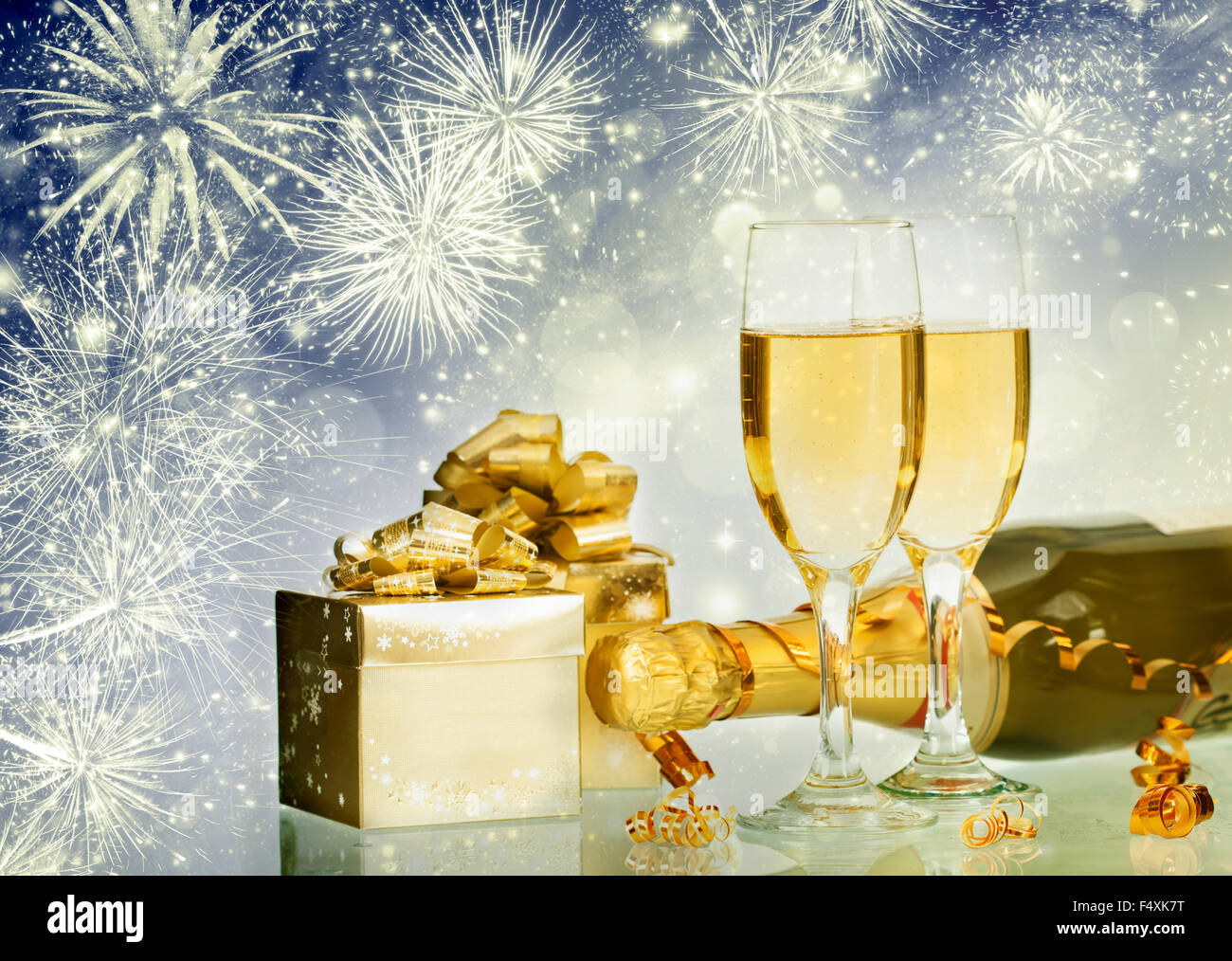 Glasses with champagne and bottle over sparkling holiday background