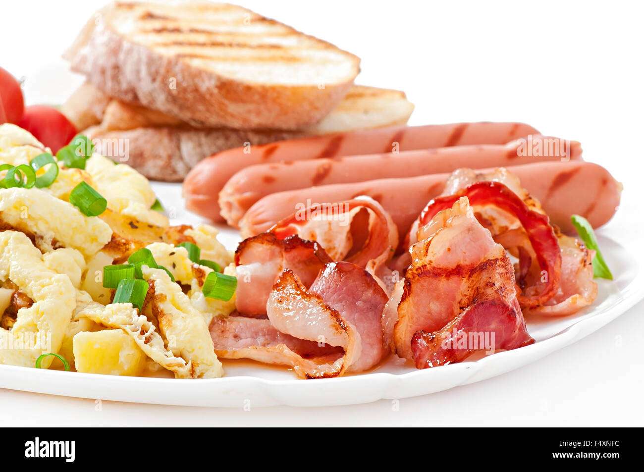 English breakfast - scrambled eggs, bacon, sausage and toast Stock Photo