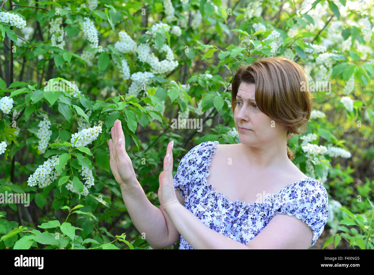 adult woman with allergic diseases removed from wild cherry blossoms Stock Photo
