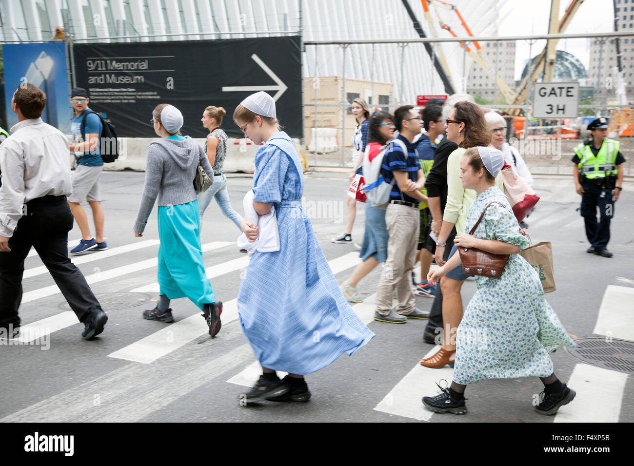 mennonite girls in traditionel dress cross the street in new york city near ground zero Stock Photo