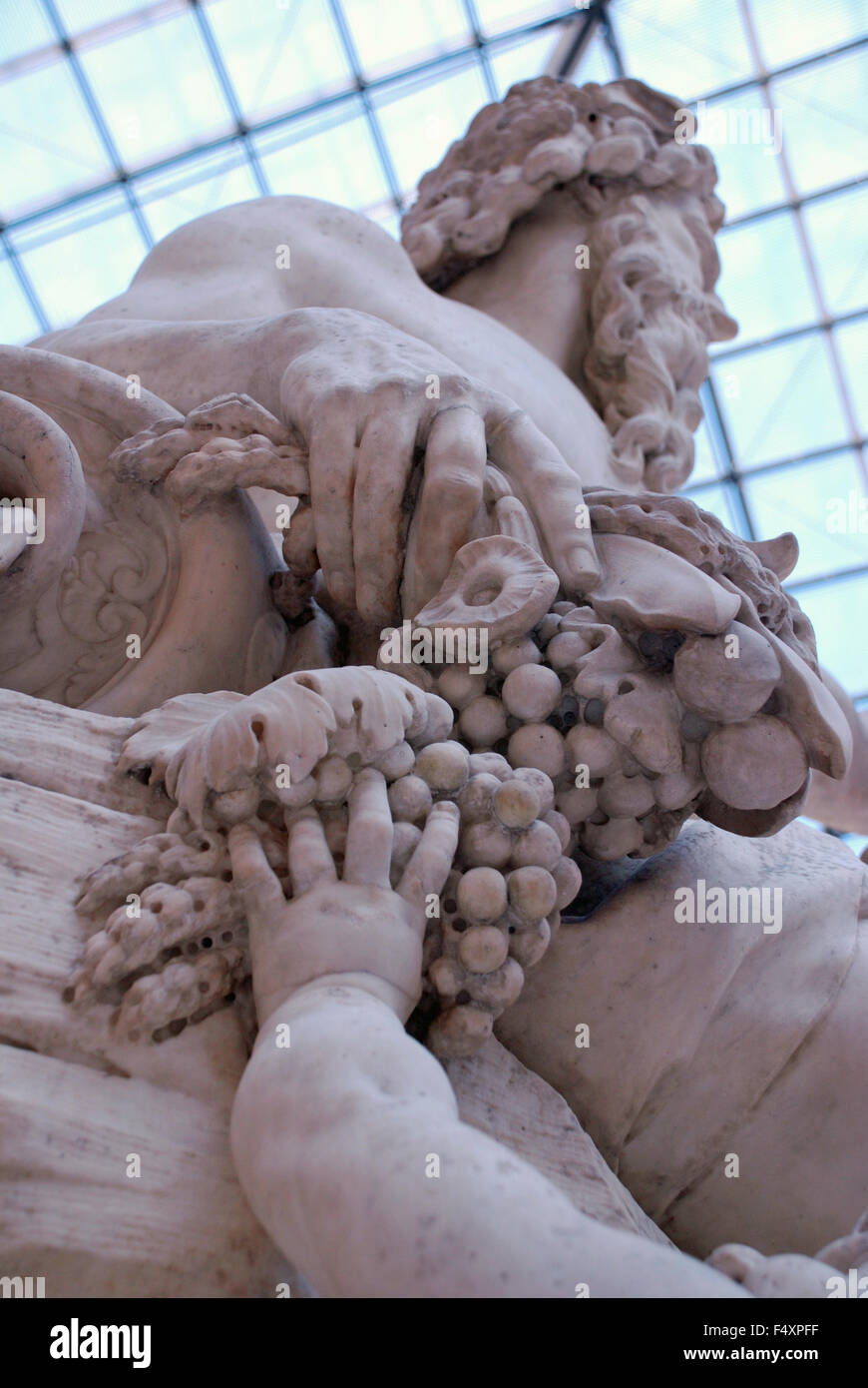 Marble sculpture of a man and boy reaching for grapes at Louvre Museum in Paris Stock Photo
