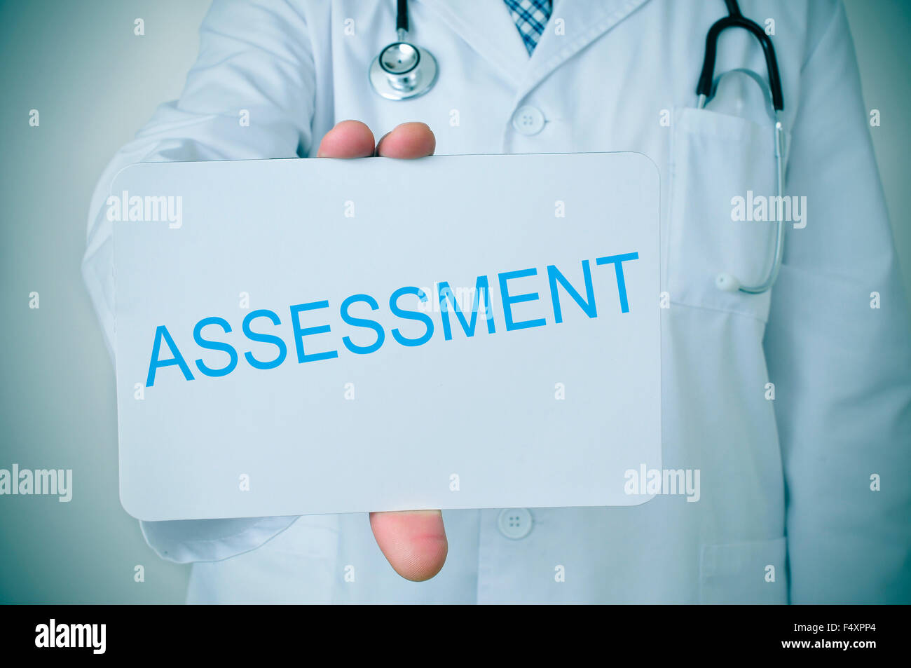 closeup of a young doctor man showing a signboard with the word assessment written in it Stock Photo