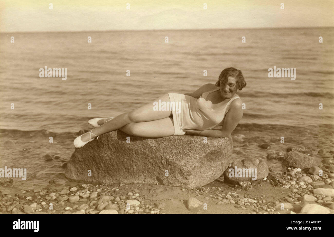 A woman in costume white sea lying on the seashore, Denmark Stock Photo