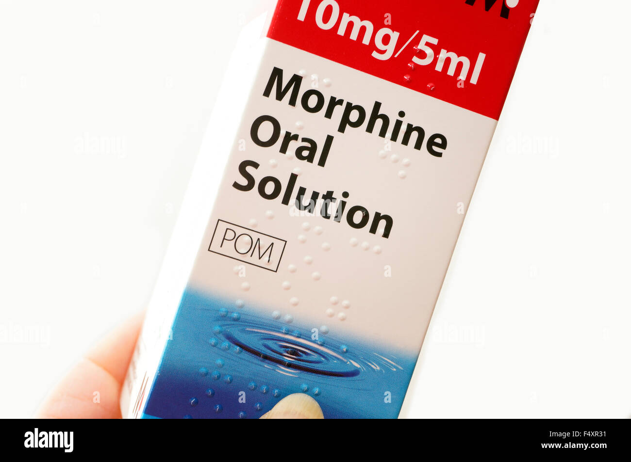 Woman holding a bottle of Morphine oral solution (morphine is an alkaloid with pain relieving properties) used for pain relief Stock Photo