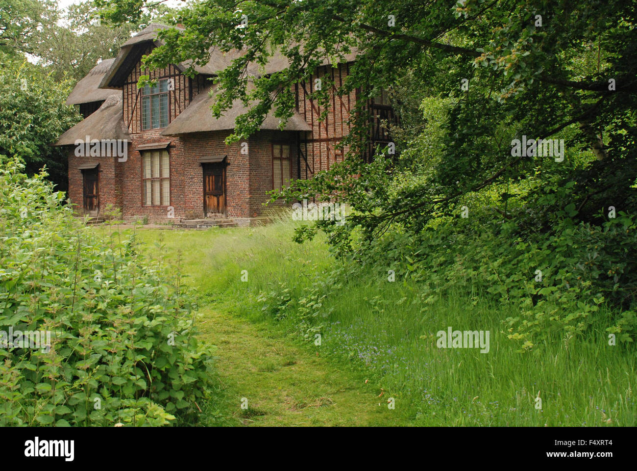Queen Charlotte's Cottage hidden in the leafy forest woods at Kew Botanical Gardens in London, England. Stock Photo