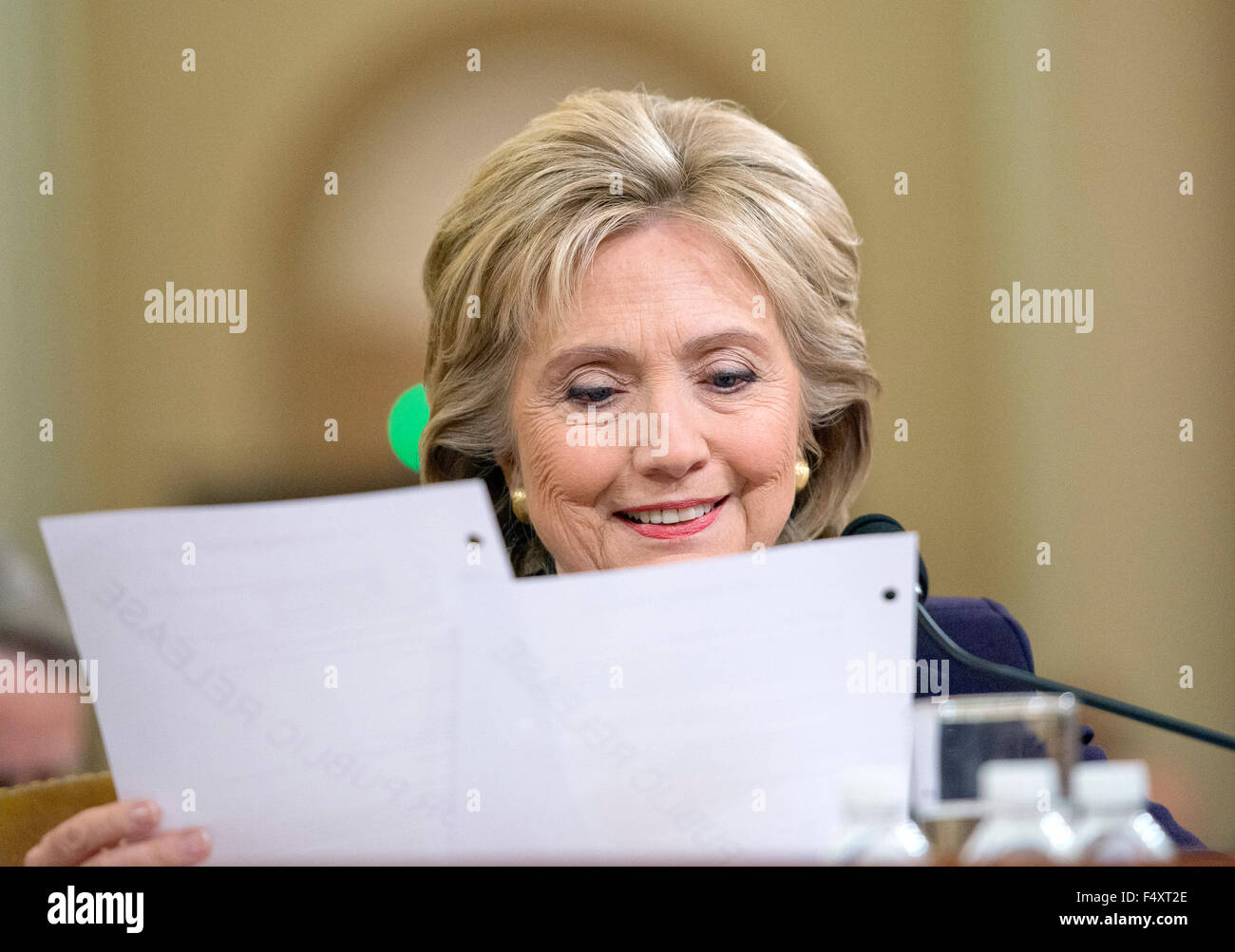 Washington DC, USA. 22nd Oct, 2015. Former United States Secretary of State Hillary Rodham Clinton, a candidate for the 2016 Democratic Party nomination for President of the United States, smiles as she reads a memo from Ambassador J. Christopher Stevens, the US envoy to Libya who was killed in the terror attack in Bengazi on September 11, 2012 as she testfies before the US House Select Committee on Benghazi on Capitol Hill in Washington, DC on Thursday, October 22, 2015. Credit: Ron Sachs/CNP (RESTRICTION: NO New York or New Jersey Newspapers or newspapers within a 75 mile radius of New York  Stock Photo