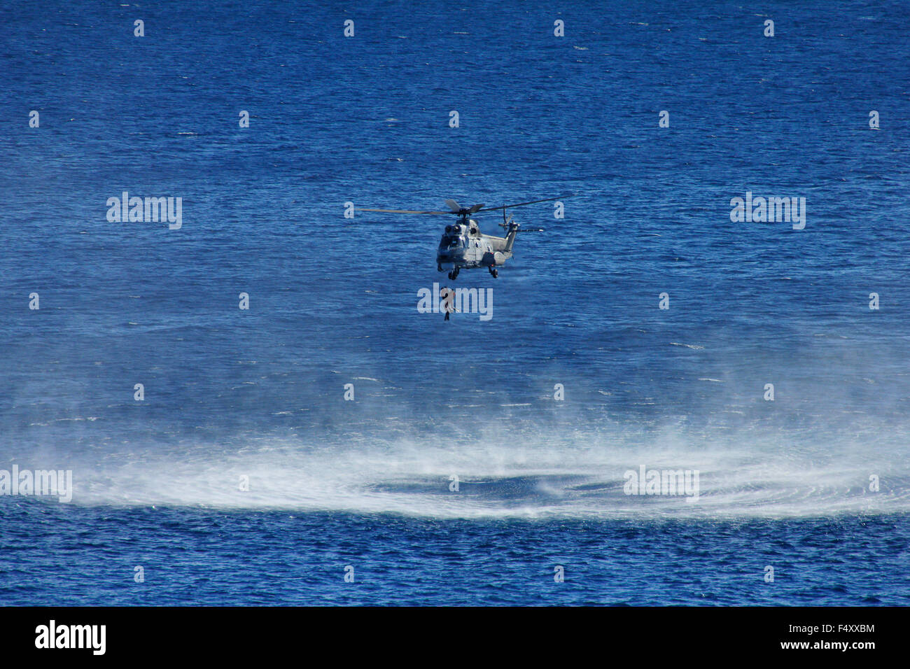 The SAR helicopter, hoisting up the drill members, ending the drill. Northeastern Aegean sea, Lemnos island, Greece Stock Photo