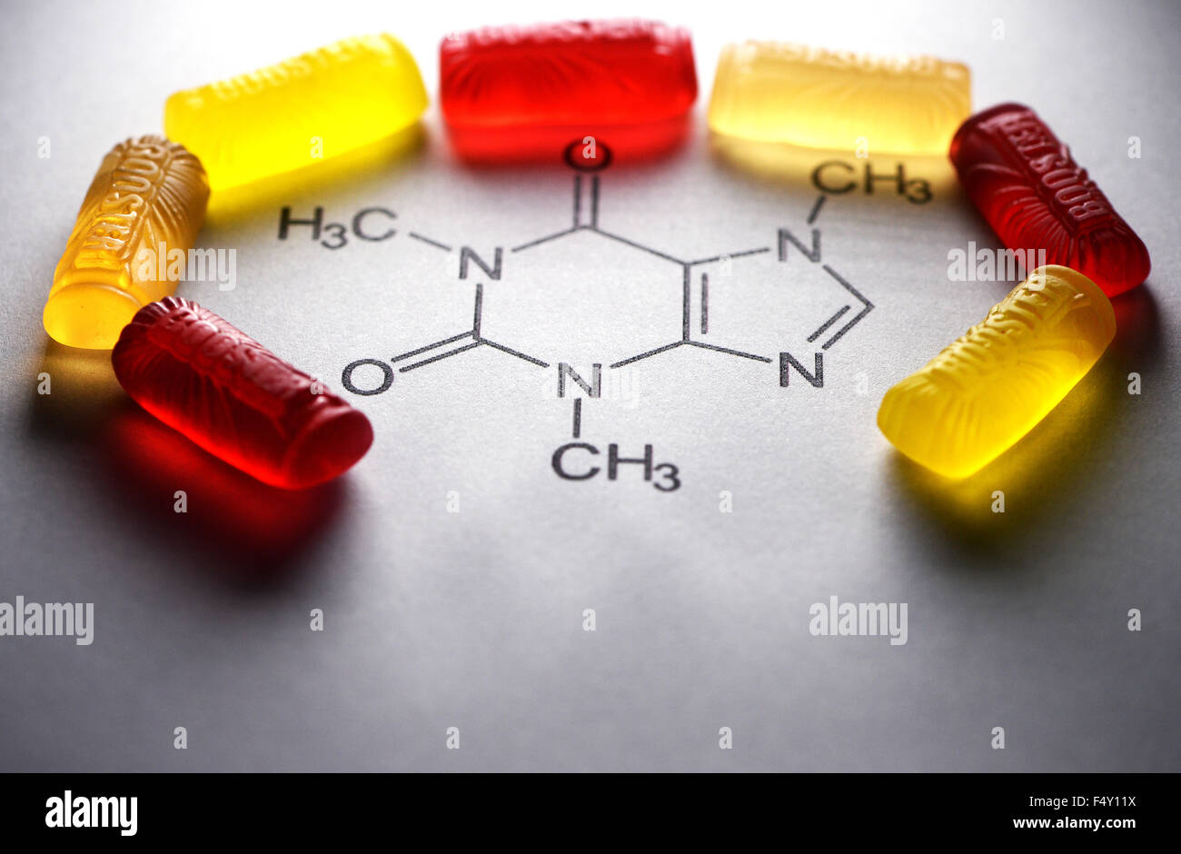 Berlin, Germany. 23rd Oct, 2015. Fruit gummy candy from the brand 'Booster Energy Sweets' lie on the structural formula for caffeine in Berlin, Germany, 23 October 2015. They are in the shape of an energy drink can. The product contains 30 milligrams of caffeine per 100 grams. The sweets are not recommended for children and pregnant women. Photo: JENS KALAENE/dpa/Alamy Live News Stock Photo