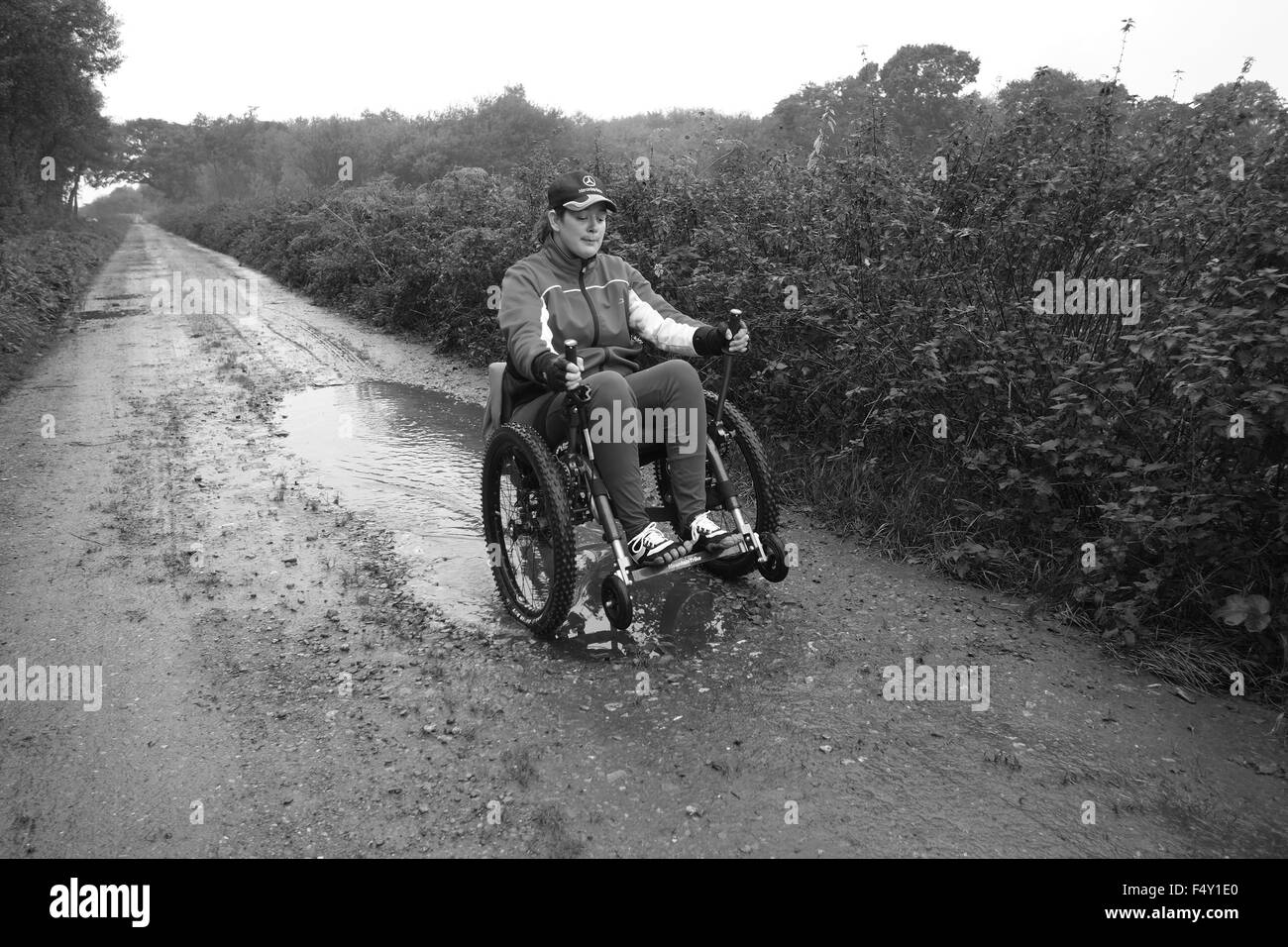 Young woman in her off road wheelchair keeping fit on a country lane in rural Somerset on the Levels. October 2015 Stock Photo