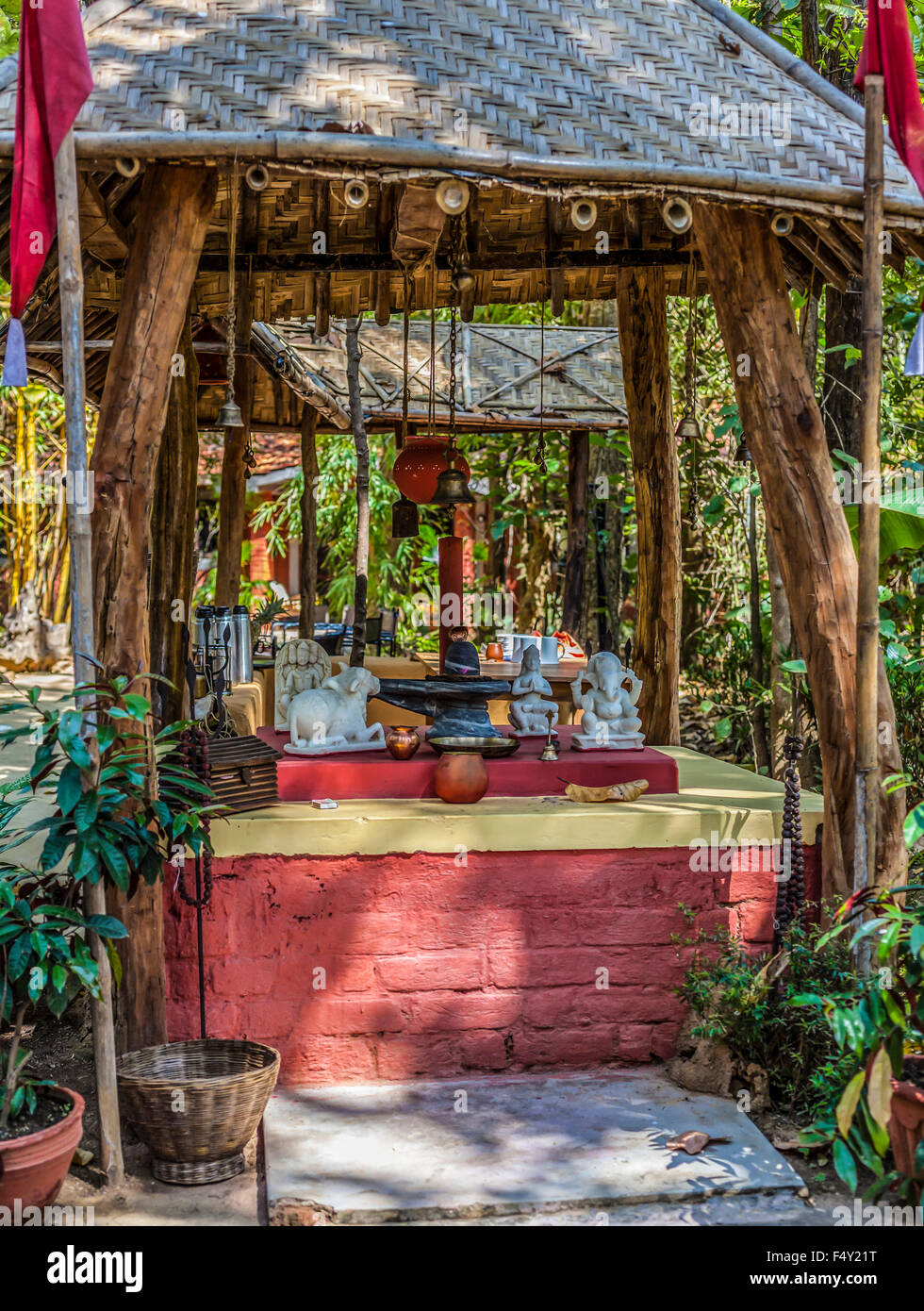 An outdoor Hindu Shrine to the god Shiva, with lingam, with statues representing Brahma, Nandi and Ganesha and trident; India Stock Photo