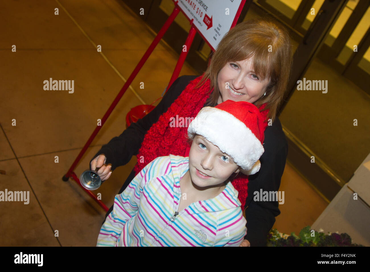 Two volunteer workers for the Salvation Army ringing their bell outside