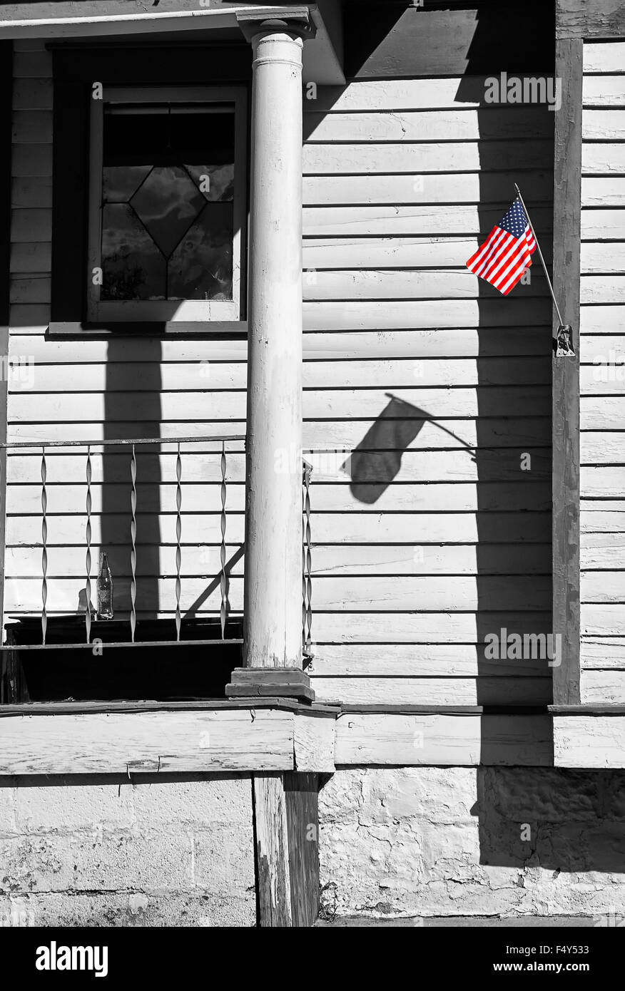 Patriotic display of small flag of USA  attached to house front. Stock Photo