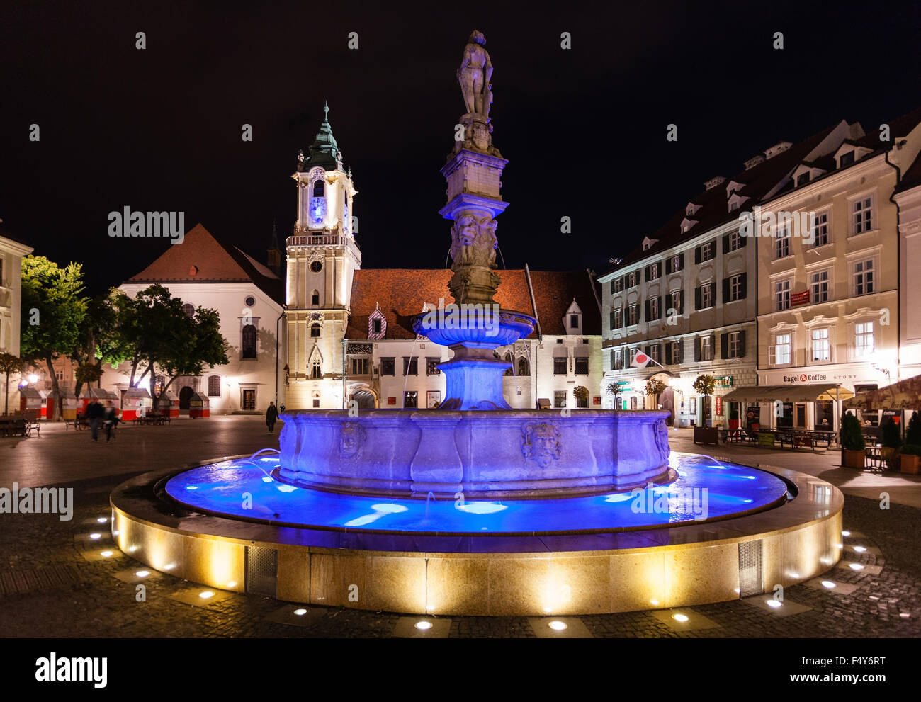 Bratislava: Illuminated Bratislava Main Square at night, with the Old Town Hall and Roland Fountain casting reflections on the wet cobblestones.