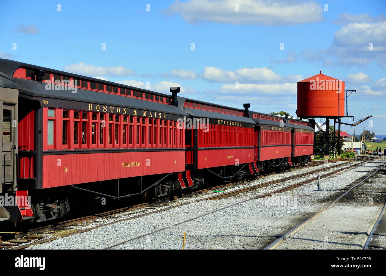 Strasburg, Pennsylvania:  Four vintage wooden passenger cars and steam engine water tower at the Strasburg Railroad Stock Photo