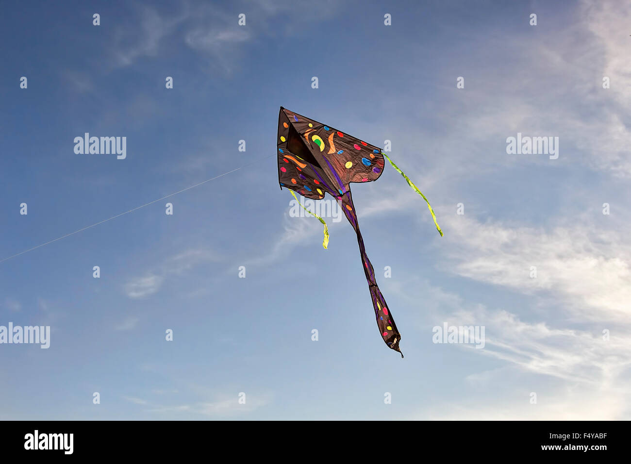 Colorful kite flying in the blue sky in autumn. Stock Photo
