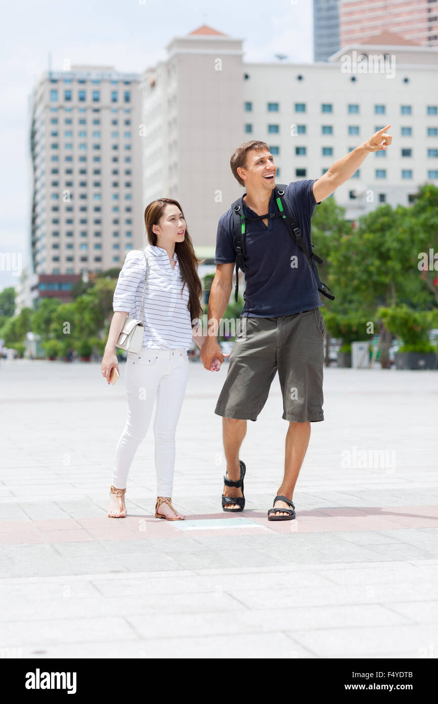 Couple asian girl and caucasian man tourist smile point finger sightseeing Stock Photo