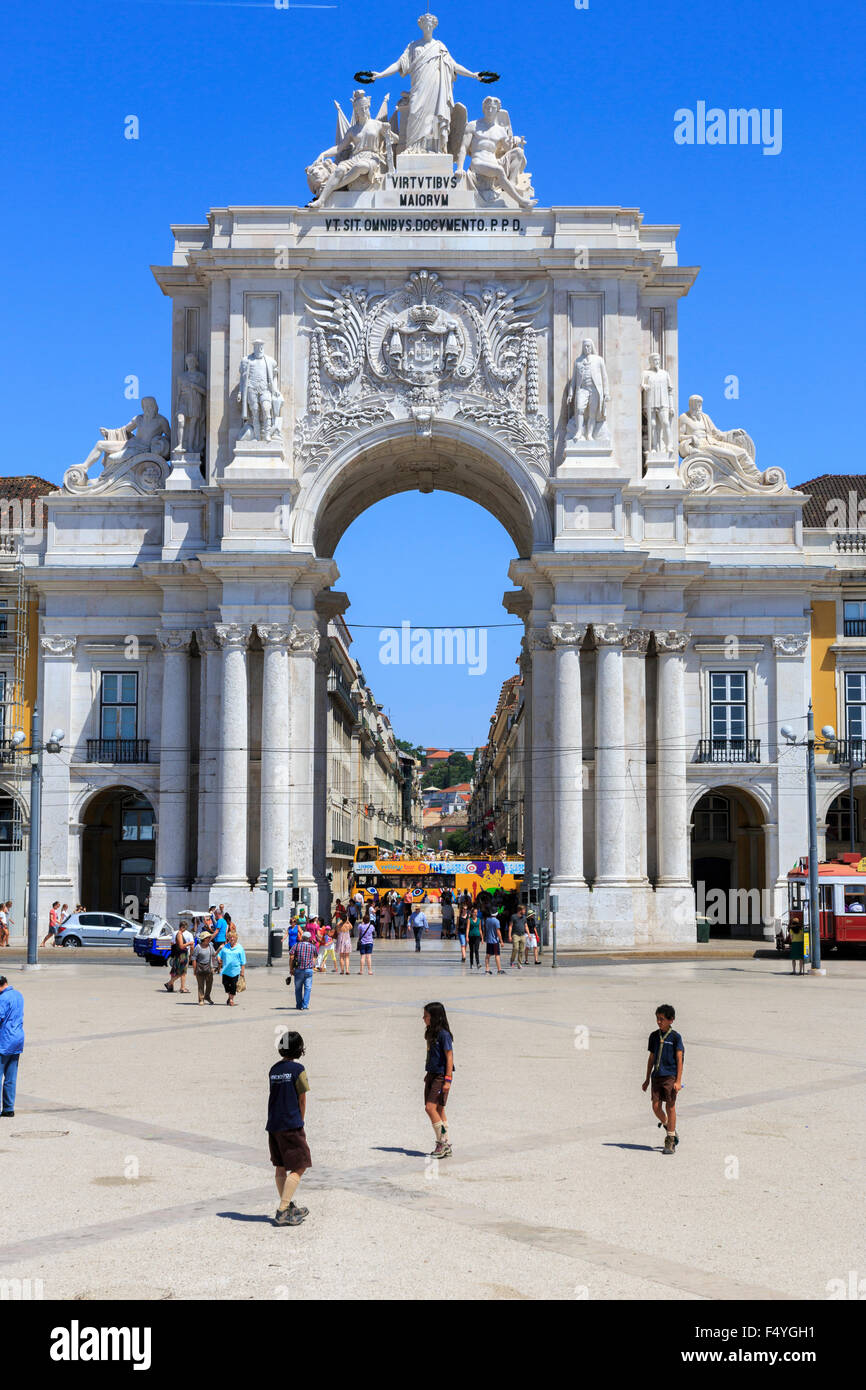 Tourists by the Arco da Rua Augusta is a stone triumphal arch-like historical building and visitor attraction on Commerce Square in Lisbon Portugal Stock Photo