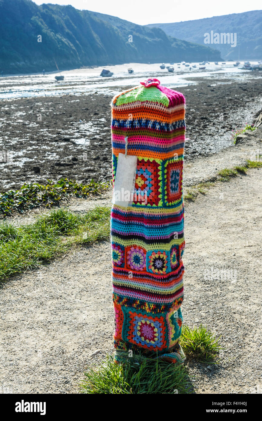 Post with knitted, woolen covers.Yarn bombing, urban knitting urban knitted. Stock Photo
