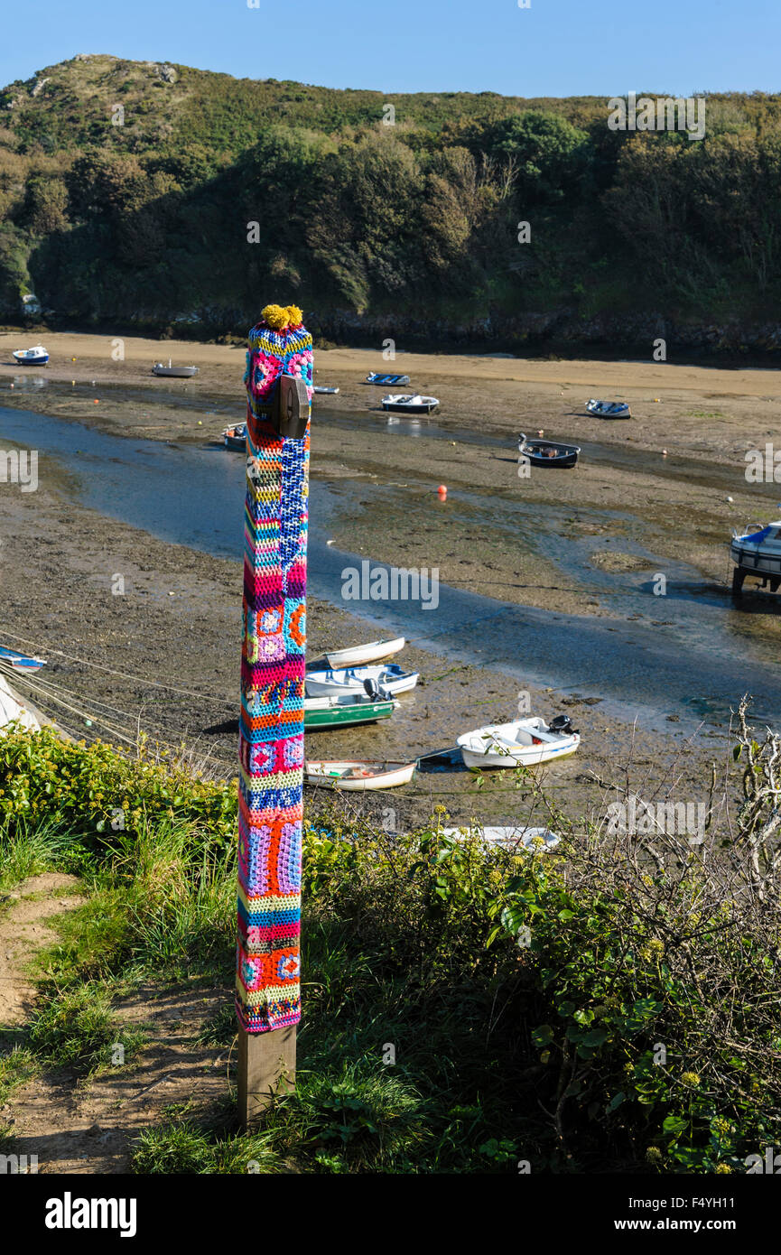 Post with knitted, woolen covers.Yarn bombing, urban knitting urban knitted. Stock Photo